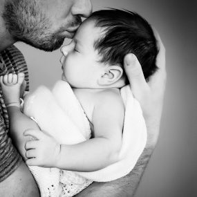 Powerful portrait of newborn baby with dad in black and white