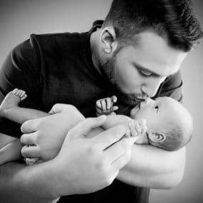 Powerful portrait of newborn baby with dad in black and white