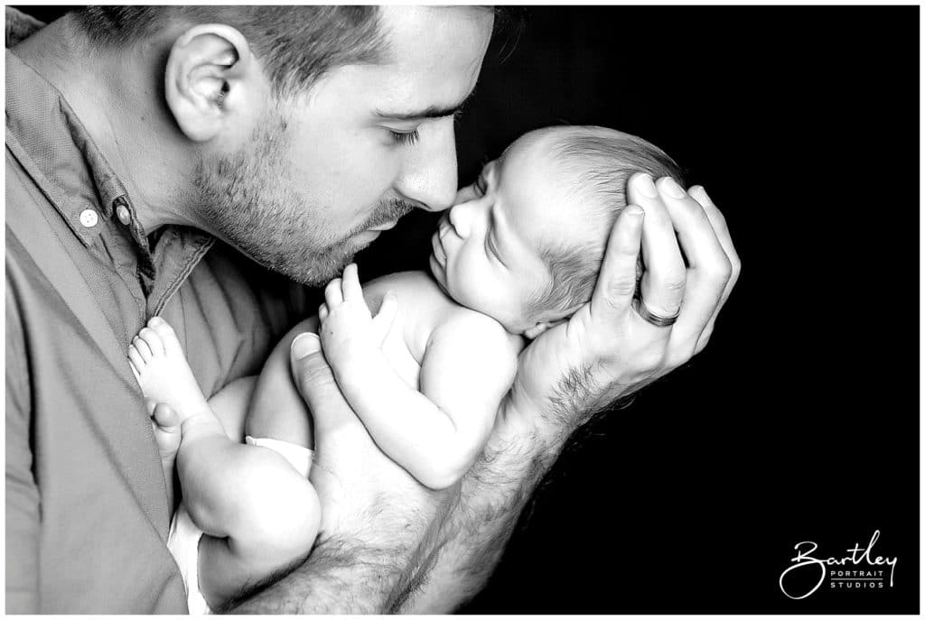 proud daddy holding newborn baby