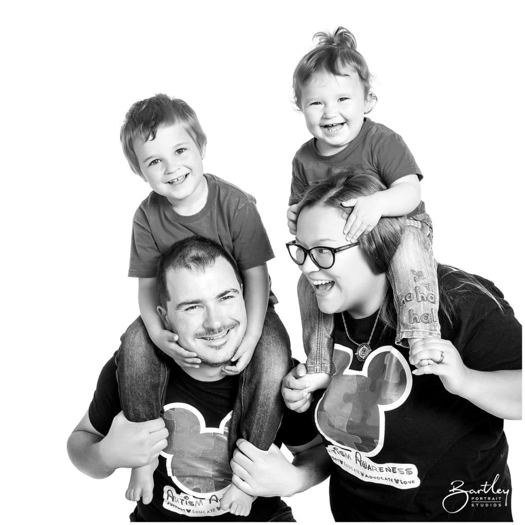 kids on parents shoulders in a family portrait