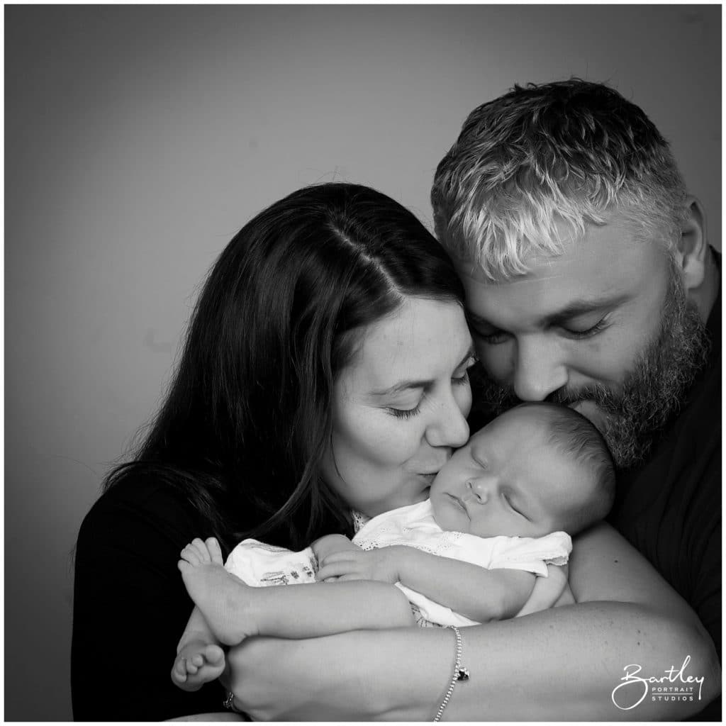 mum kissing baby in photography studio