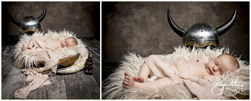 newborn baby sleeping next to viking helmet