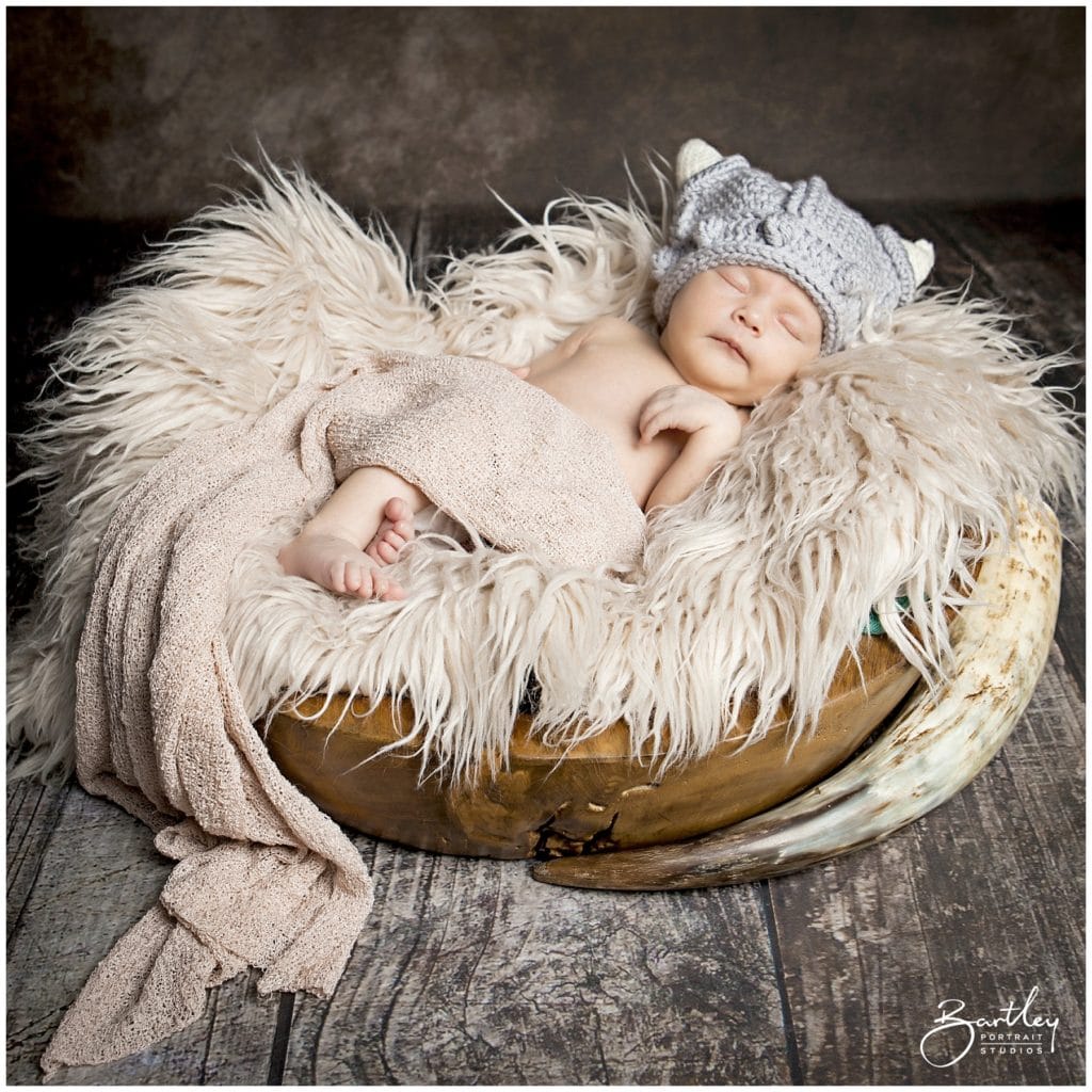 baby in viking knitted helmet asleep with drinking horn