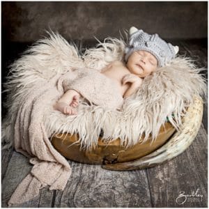 baby in viking knitted helmet asleep with drinking horn