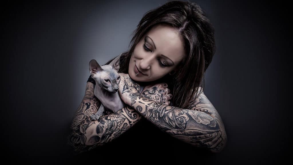 woman with sphynx cat hairless tattoos colour portrait studio photography